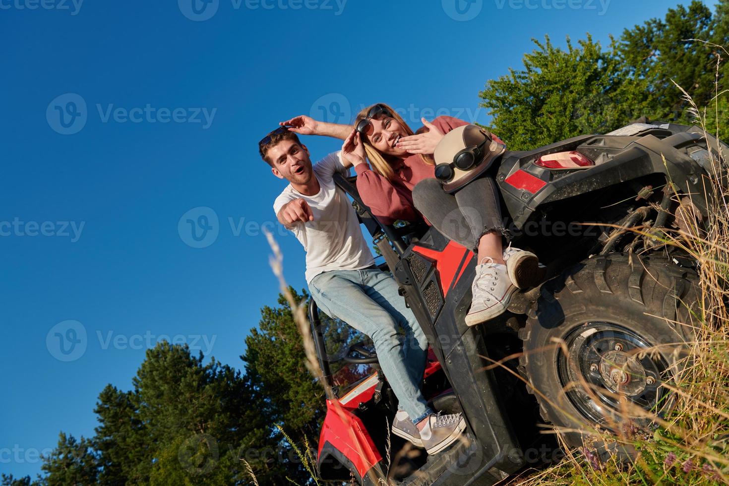 Ein Paar genießt einen schönen sonnigen Tag, während es einen Offroad-Buggy fährt foto