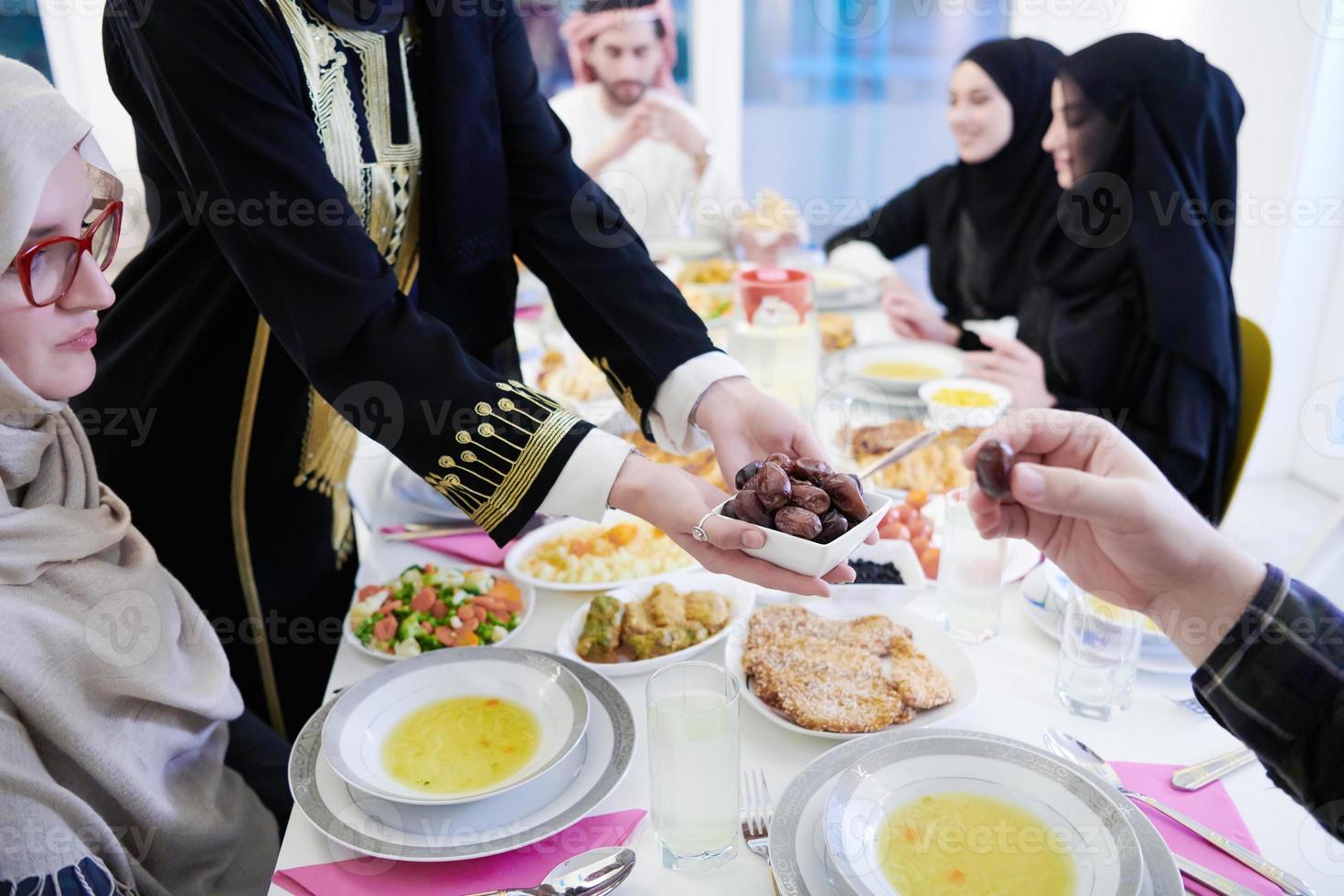 muslimische familie beim iftar-abendessen, das datteln isst, um das fest zu brechen foto