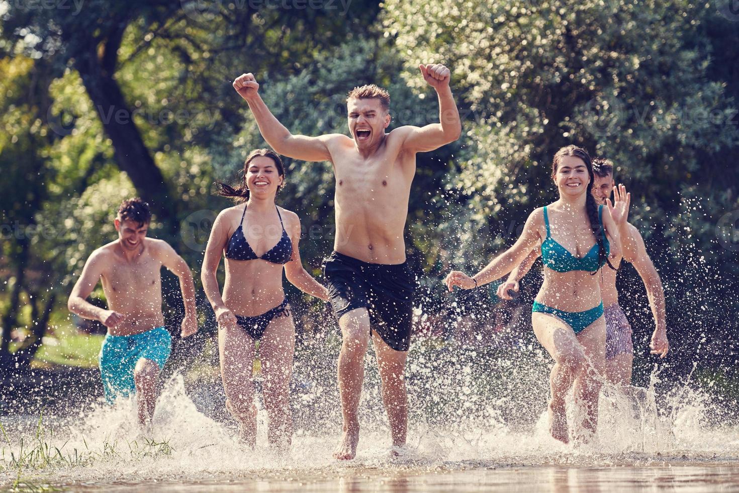 gruppe glücklicher freunde, die spaß am fluss haben foto