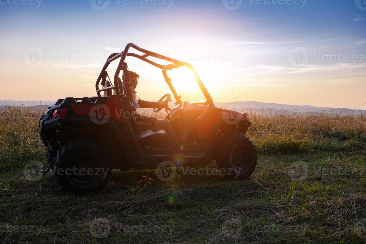 Porträt eines jungen Mannes, der ein Offroad-Buggy-Auto fährt foto