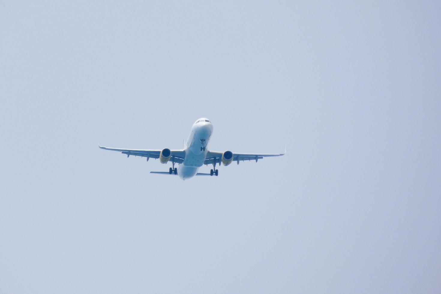 Verkehrsflugzeuge, die unter blauem Himmel fliegen und am Flughafen ankommen foto