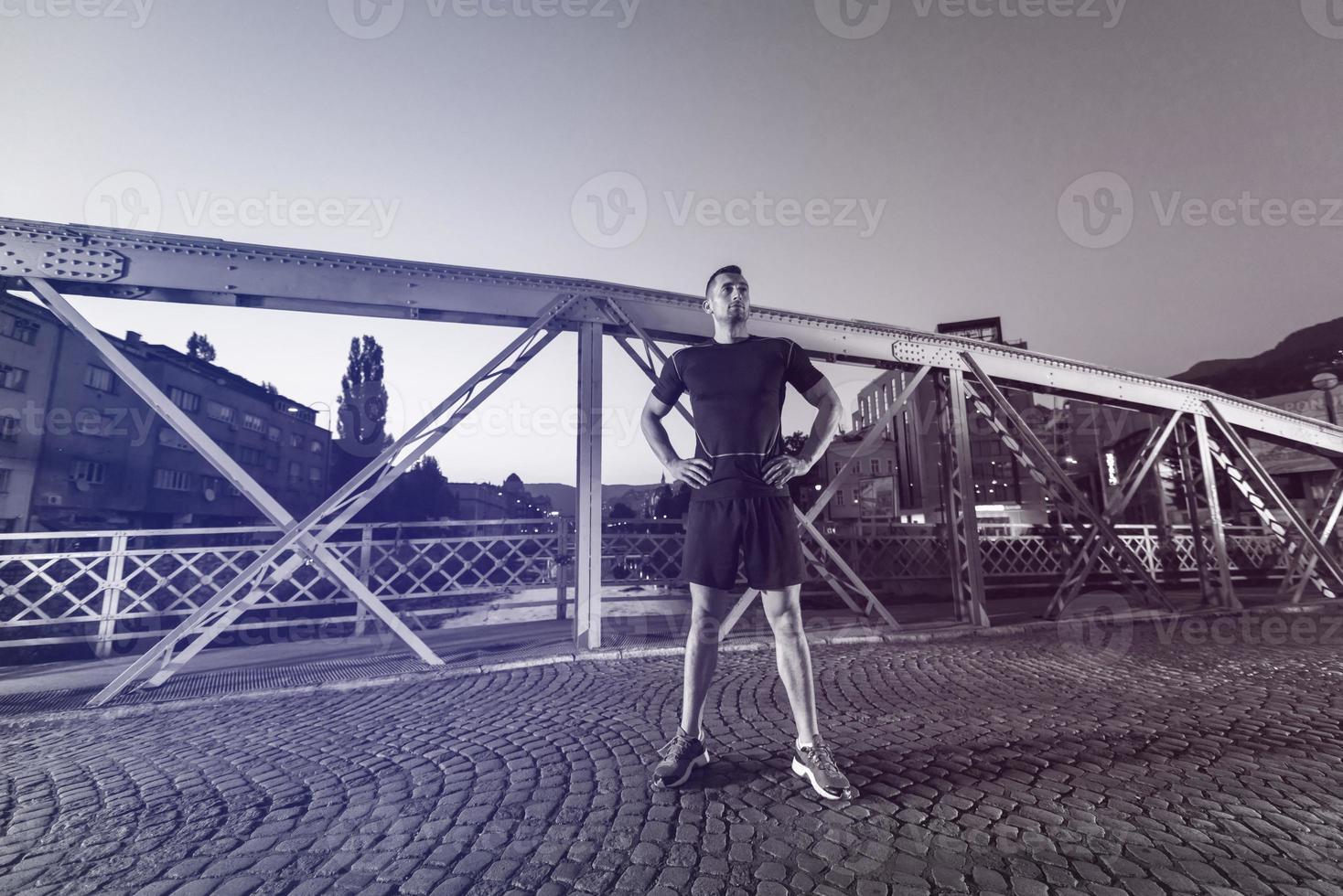 Mann joggt über die Brücke in der Stadt foto