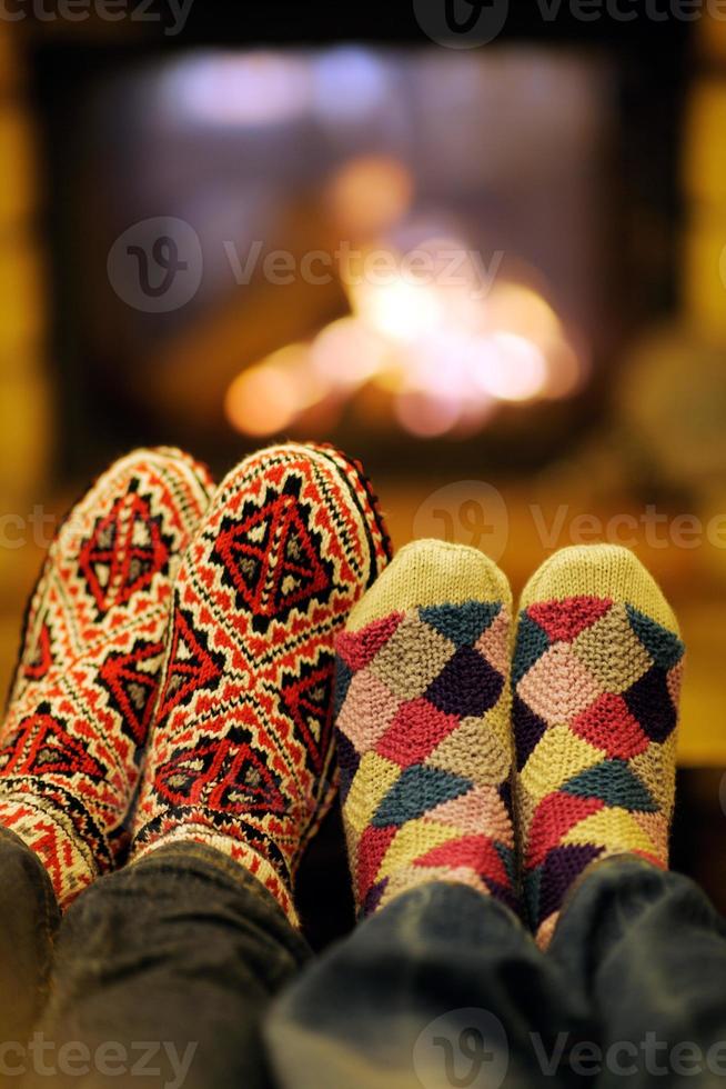 junges romantisches paar entspannen sich auf dem sofa vor dem kamin zu hause foto