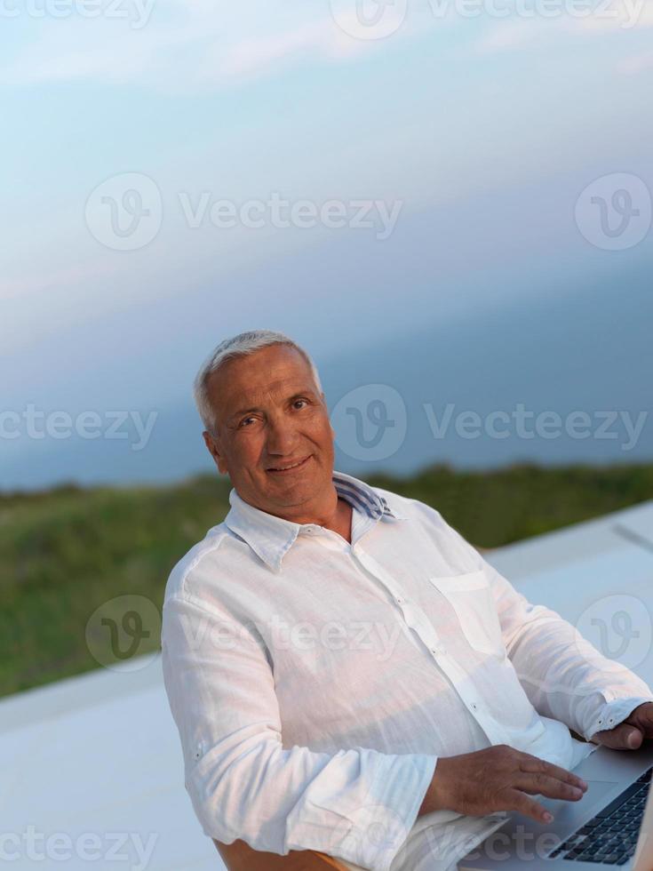 Entspannter älterer Mann auf dem Balkon foto