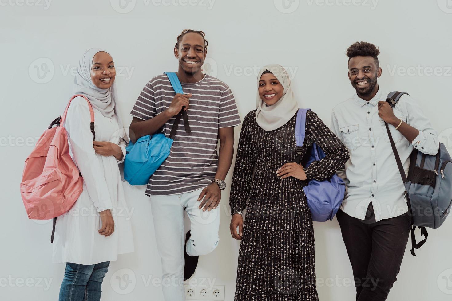 Foto einer Gruppe glücklicher afrikanischer Studenten, die miteinander reden und sich treffen, um an Hausaufgaben zu arbeiten, Mädchen, die traditionellen sudanesischen muslimischen Hijab tragen