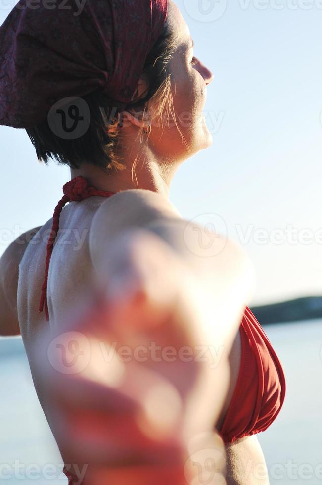 glückliches mädchen, das hände ausbreitet und im sonnenlicht genießt foto