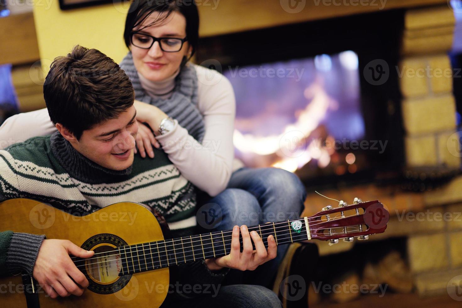 junges romantisches paar entspannen sich auf dem sofa vor dem kamin zu hause foto