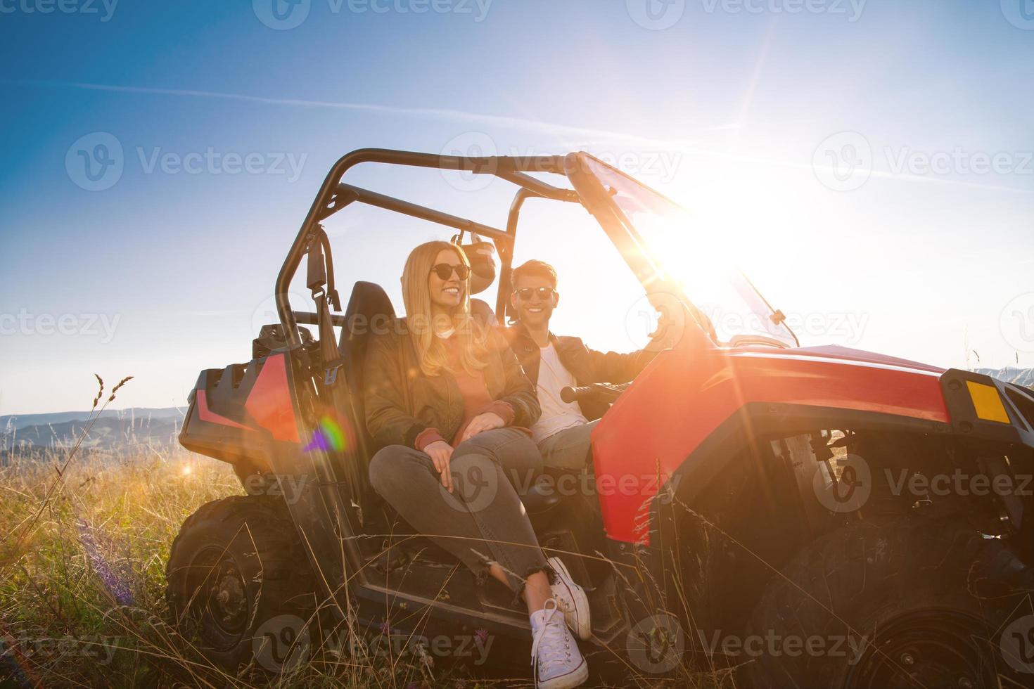 junges Paar, das ein Offroad-Buggy-Auto fährt foto