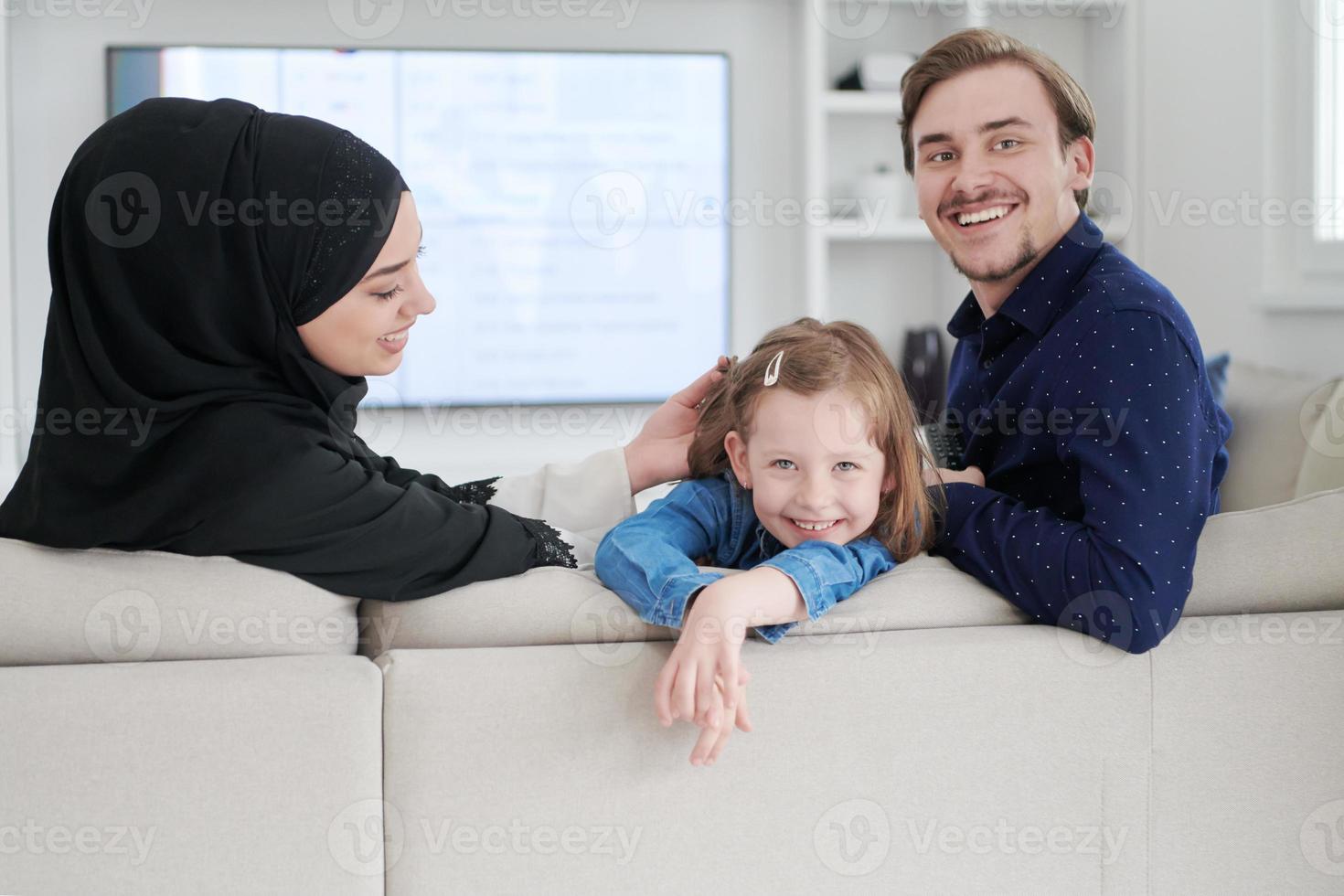 glückliche muslimische Familie, die sich zu Hause amüsiert foto