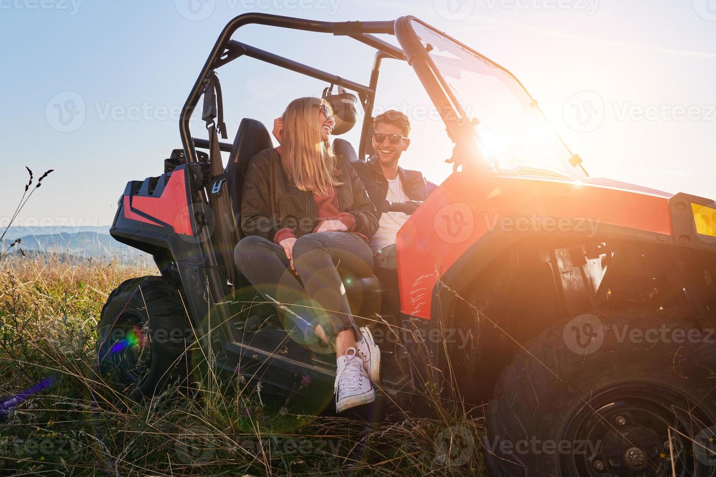 Ein Paar genießt einen schönen sonnigen Tag, während es einen Offroad-Buggy fährt foto