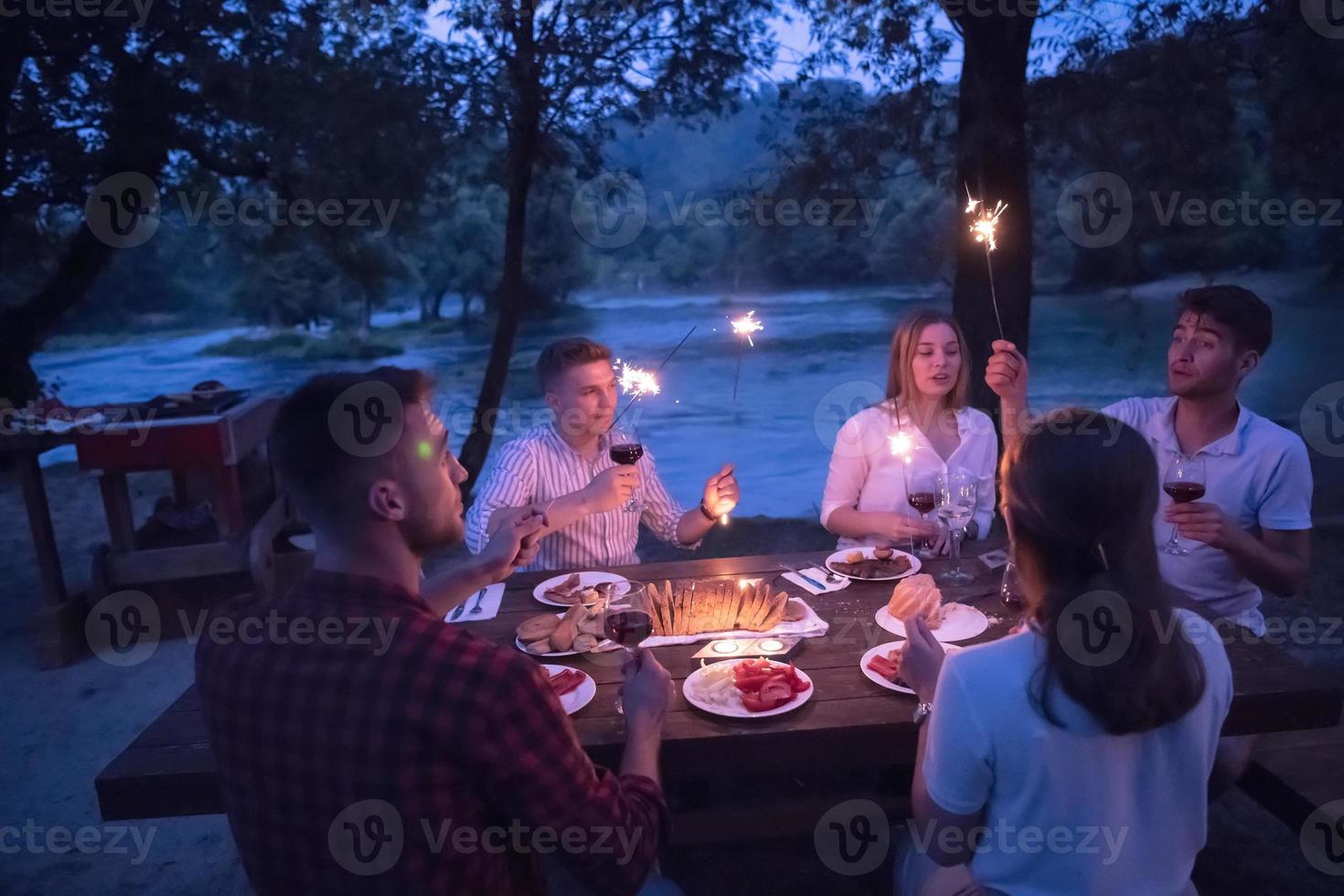 Freunde, die während der Sommerferien ein französisches Picknick im Freien haben foto