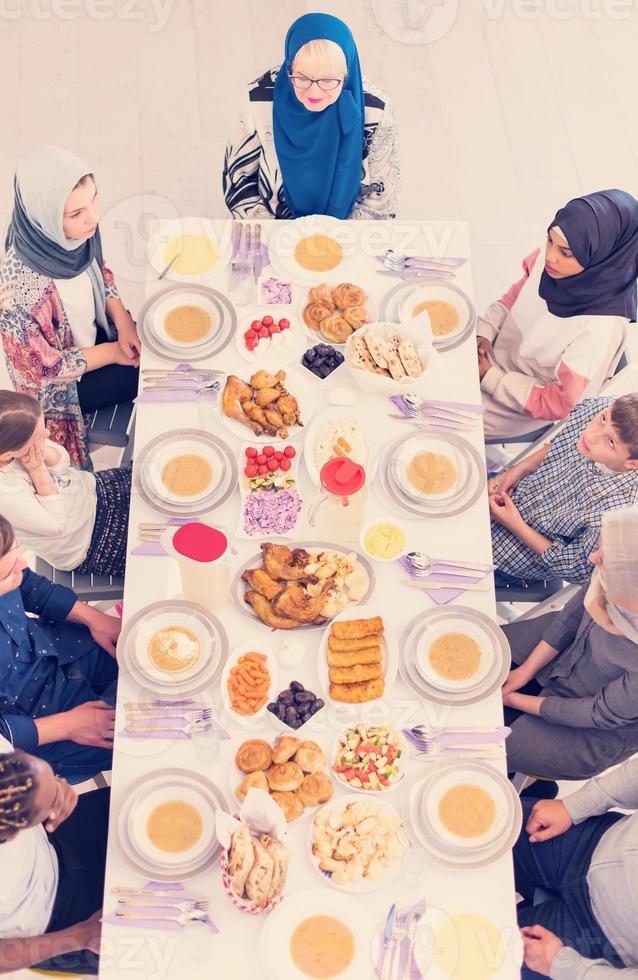 Draufsicht der modernen multiethnischen muslimischen Familie, die auf den Beginn des Iftar-Abendessens wartet foto