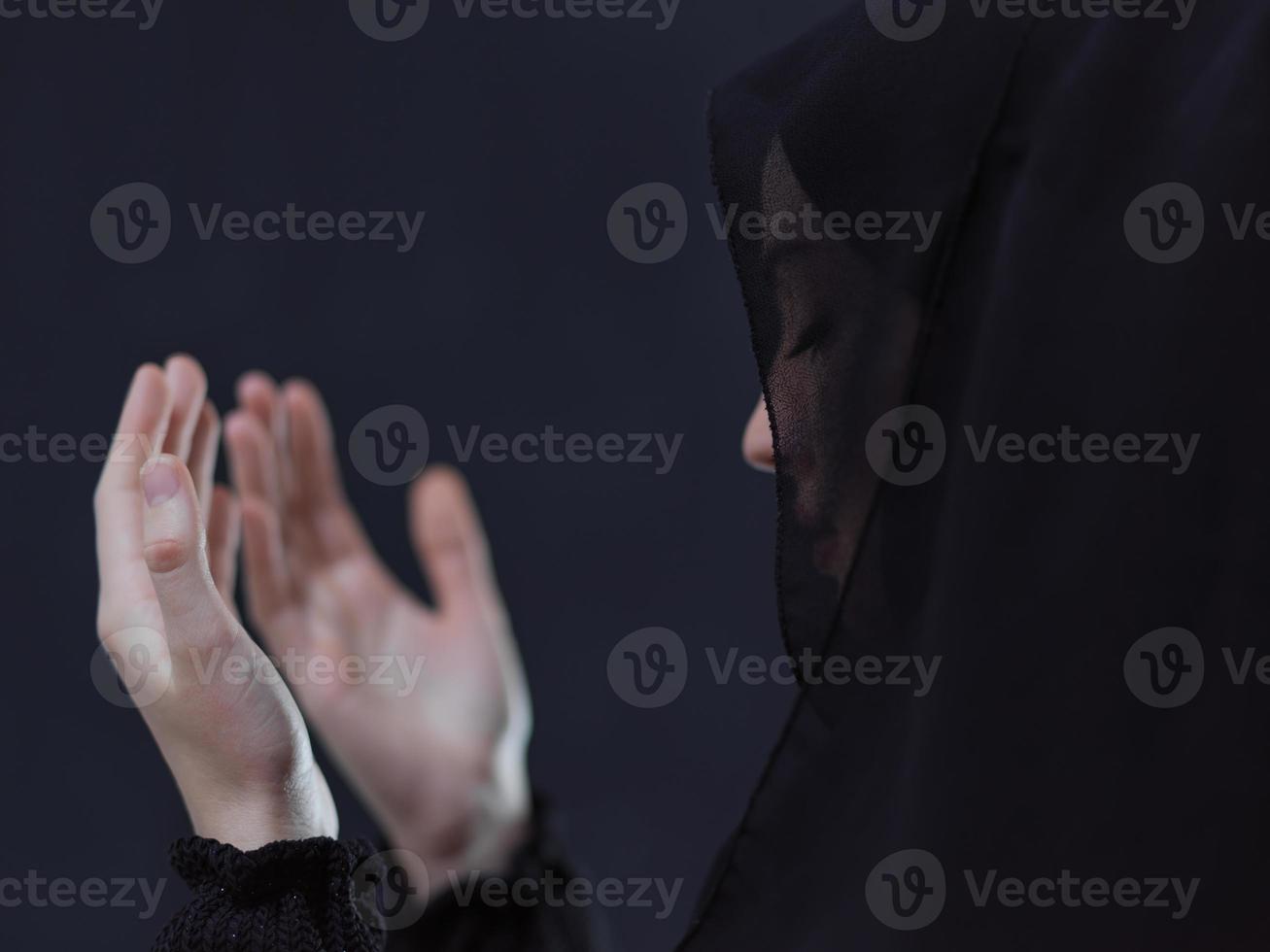 muslimische frau, die traditionelles beten zu gott vor schwarzer tafel macht foto