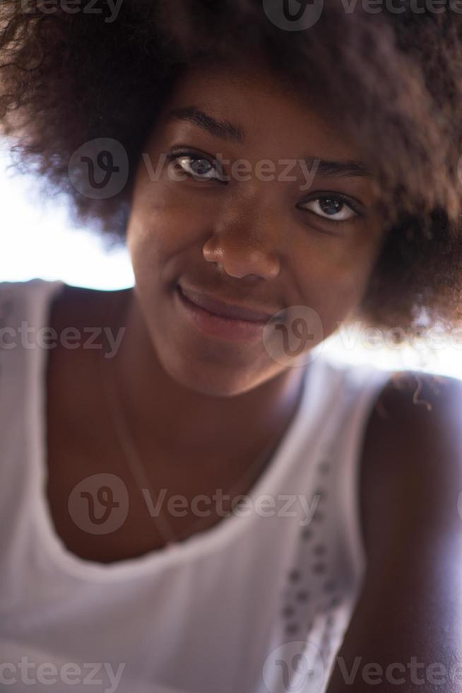 Nahaufnahme Porträt einer schönen jungen afroamerikanischen Frau, die lächelt und nach oben schaut foto