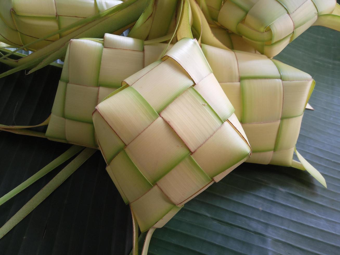 ketupat ist in indonesien eine art, reis zu kochen, indem reis in ein kokosnussblatt gesteckt wird, das wie ein diamant geformt ist. dann gedämpft. sehr berühmt in indonesien. erscheint normalerweise auf eid al-fitr foto