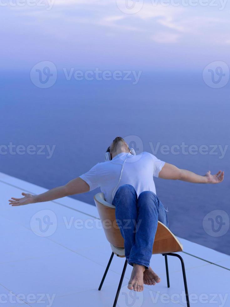 Entspannter junger Mann zu Hause auf dem Balkon foto