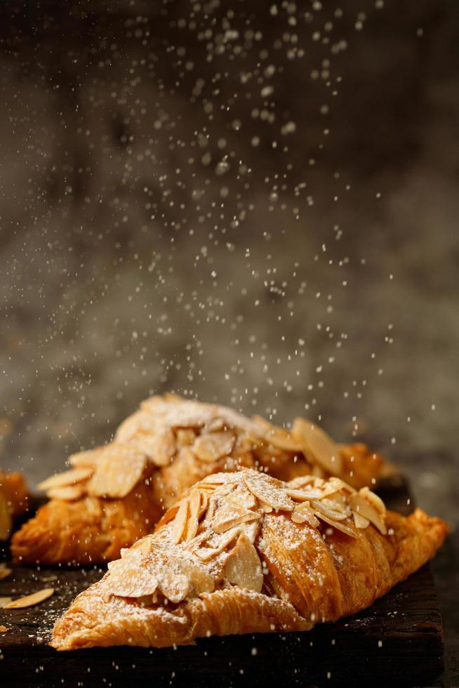 frisch gebackene Croissants mit Mandelset aus köstlichen frischen Tellern auf Holztisch. französisches frühstück. Draufsicht-Kopierraum-Banner. foto