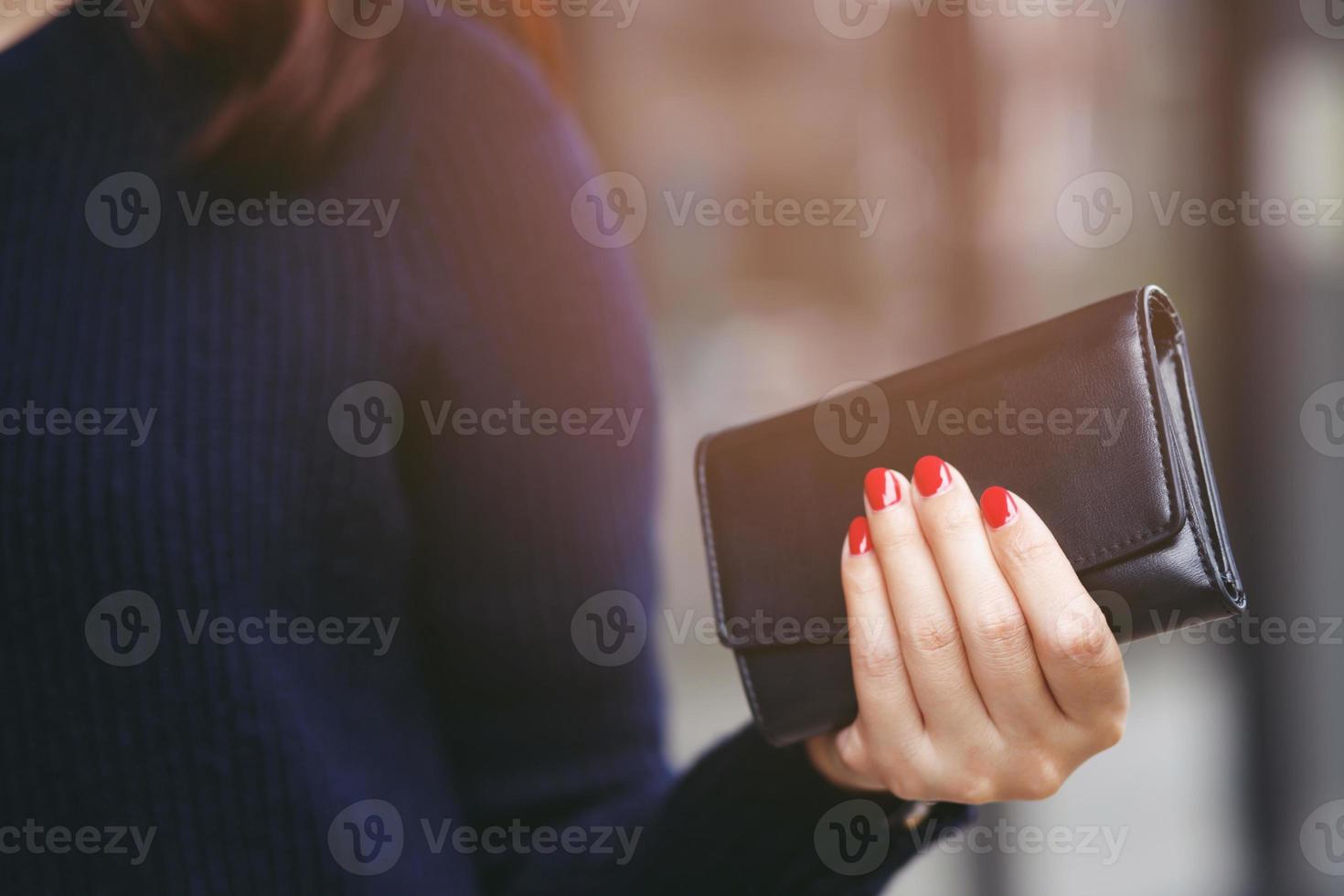 Frauenperson, die eine Brieftasche in der Hand hält. kostenkontrolle kosteneinkauf im konzept. Lassen Sie Platz, um beschreibenden Text zu schreiben foto