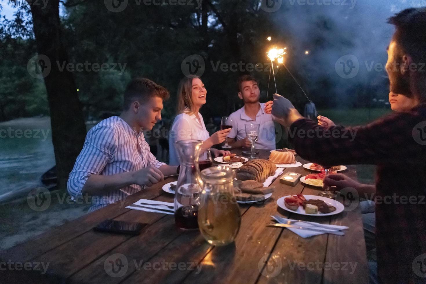 Freunde, die während der Sommerferien ein französisches Picknick im Freien haben foto