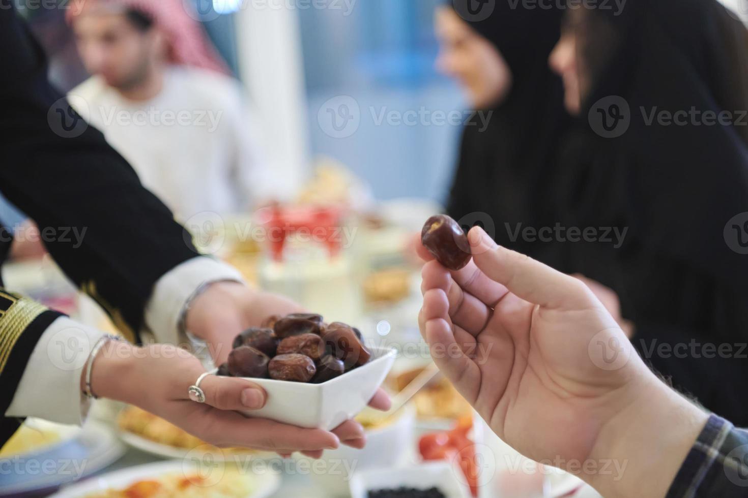 muslimische familie, die iftar mit datteln während des ramadan beginnt foto