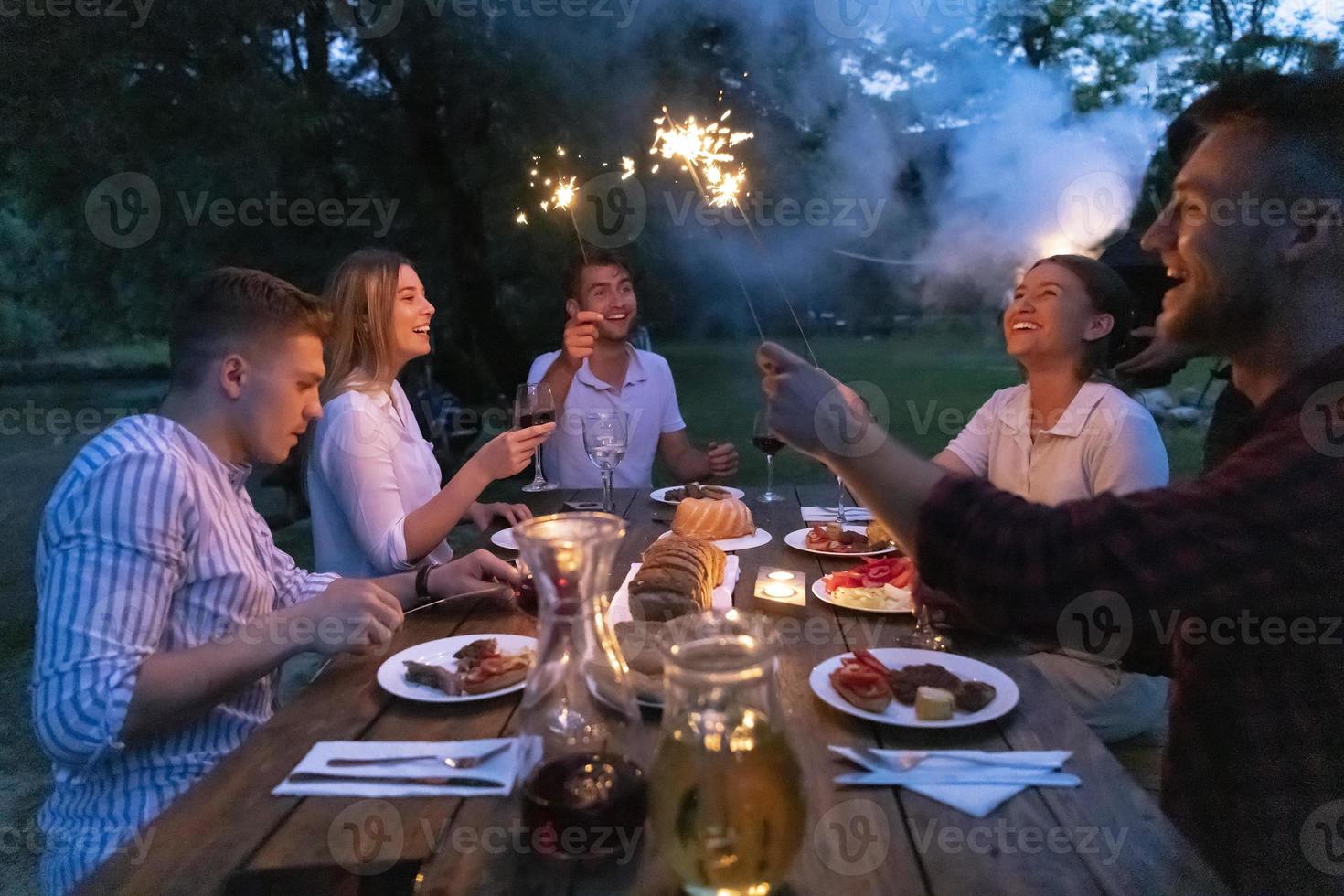 Freunde, die während der Sommerferien ein französisches Picknick im Freien haben foto