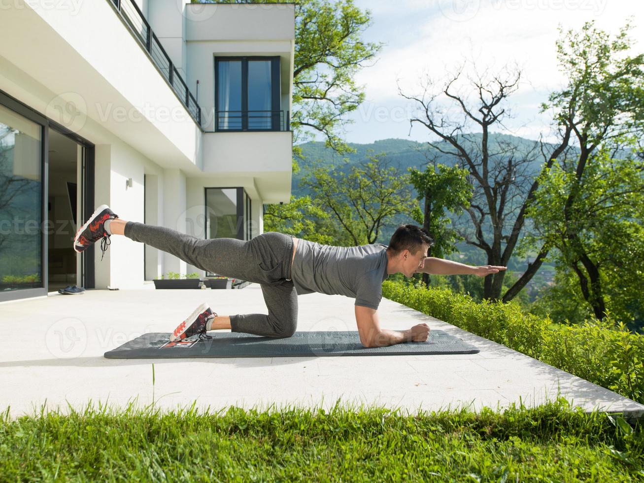 Mann, der morgendliche Yoga-Übungen macht foto