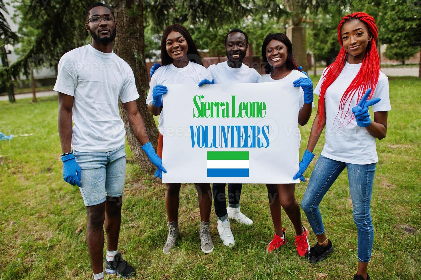 gruppe glücklicher afrikanischer freiwilliger hält leer mit sierra leone flagge im park. Freiwilligenarbeit, Wohltätigkeit, Menschen und Ökologiekonzept der afrikanischen Länder. foto