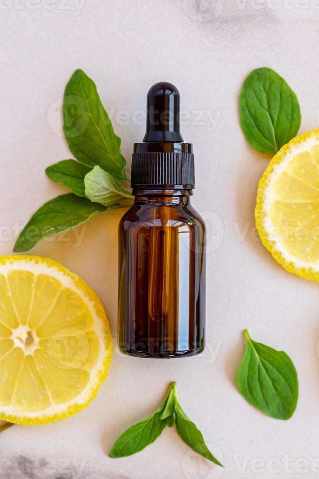 dunkle glasflasche mit ätherischem zitrusfruchtöl, vitamin c-serum, schönheitspflege-aromatherapie foto