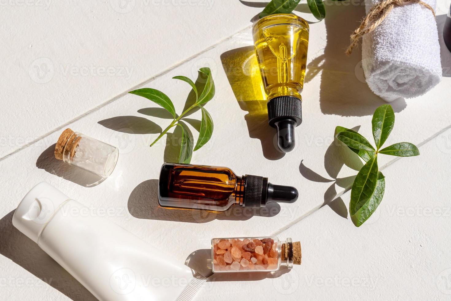 Natürliche ätherische Öle in Tropfflaschen aus Glas mit Himalaya-Salz, Baumwolltuch auf Holzhintergrund. markenlose Packung mit Schönheitsbehandlungsartikeln. foto