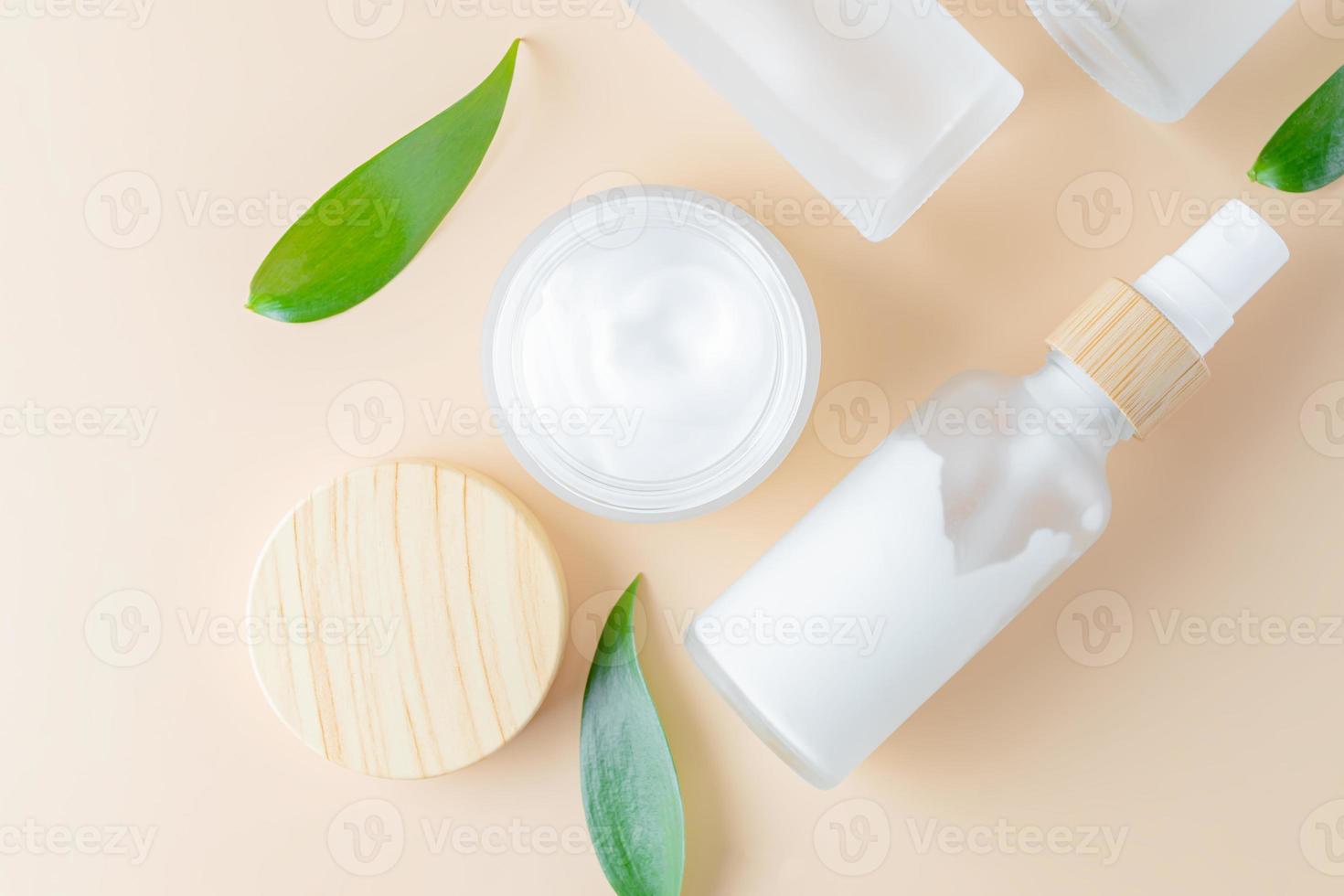 Modelle von kosmetischen Behältern. trendiger hintergrund für branding und verpackungspräsentation. natürliches hautpflege-schönheitsproduktkonzept. Serum, Creme, Essenz und Spray-Beauty-Set mit grünen Blättern foto