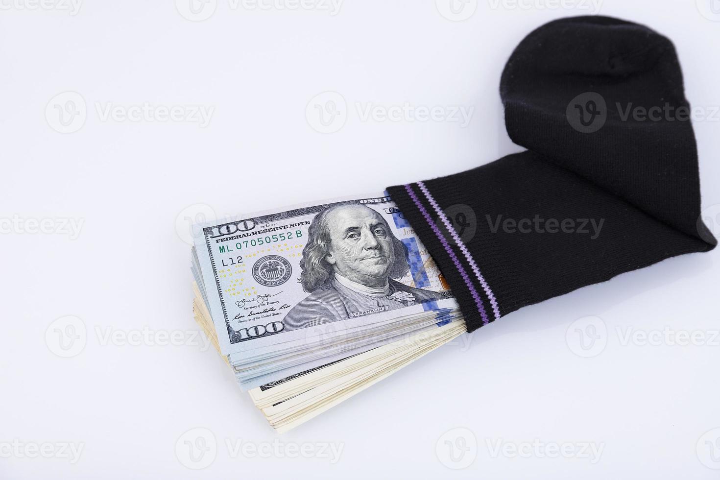 Geld Socke. Ein Bündel amerikanischer Hundert-Dollar-Scheine, die in einer Socke versteckt sind. Spar- und Speicherkonzept. selektiver Fokus foto