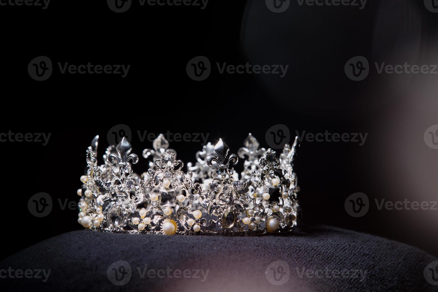 Diamant-Silberkrone für Miss-Schönheitswettbewerb, Kristall-Tiara-Schmuck verziert mit Edelsteinen und abstrakter dunkler Hintergrund auf schwarzem Samtstoff, Makrofotografie-Kopienraum für Textlogo foto