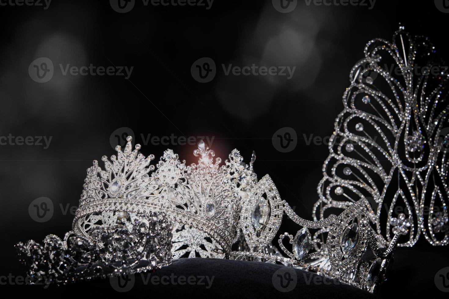 Diamant-Silberkrone für Miss-Schönheitswettbewerb, Kristall-Tiara-Schmuck verziert mit Edelsteinen und abstrakter dunkler Hintergrund auf schwarzem Samtstoff, Makrofotografie-Kopienraum für Textlogo foto