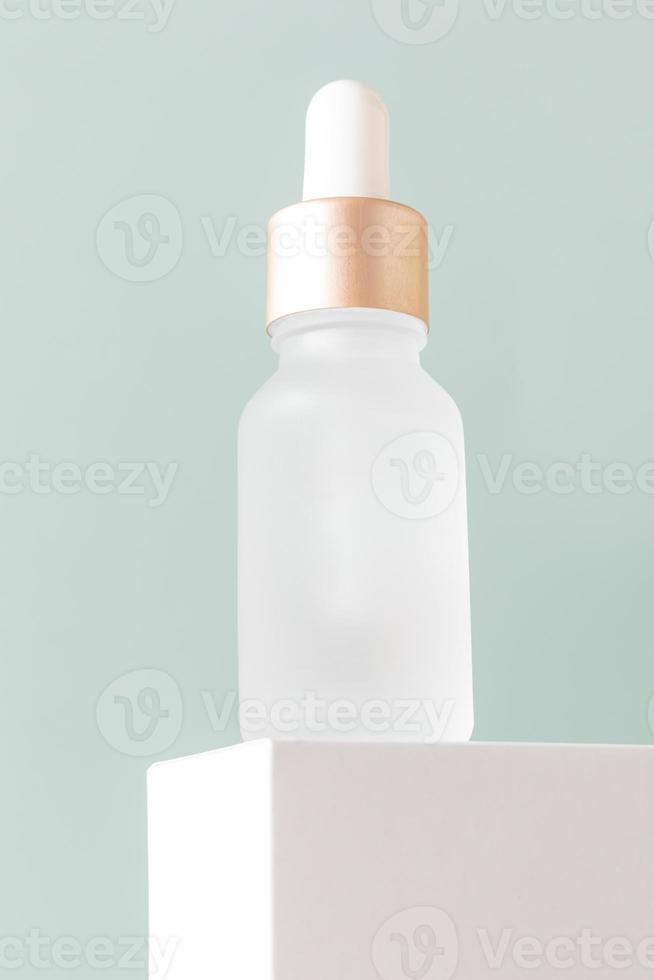 Kosmetikprodukt für die Gesichtspflege. Serum in Milchglasflasche mit Pipette. Ätherisches Öl zur Pflege der weiblichen Haut. hautpflege, feuchtigkeitsspendendes schönheitsprodukt auf blauem hintergrund. foto