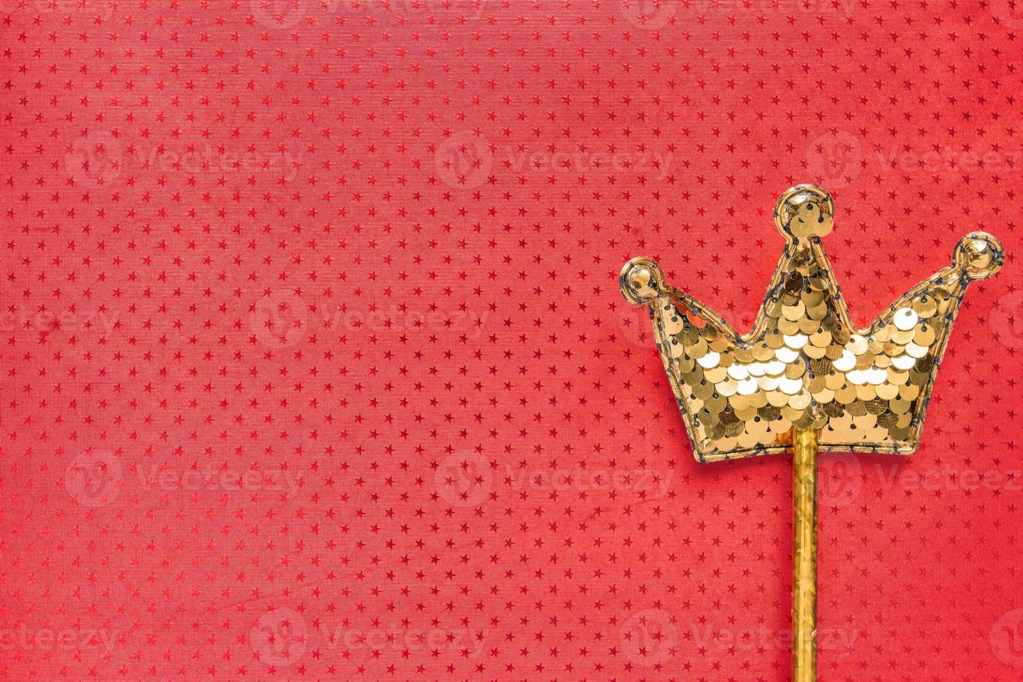 Goldener Zauberstab aus Pailletten in Kronenform auf rotem Hintergrund. kreative flache lage im minimalen stil. Platz für Text kopieren foto