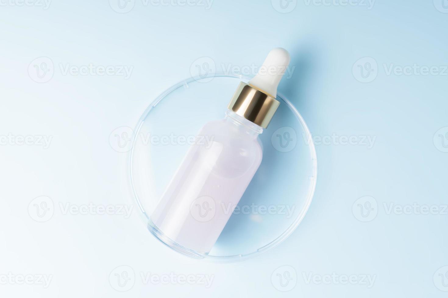 Hautpflege-Essenzöl-Tropfglasflasche auf blauem Hintergrund. feuchtigkeitsspendendes Serum, Vitamin für die Gesichtshaut. Ästhetik, Minimalismus. foto