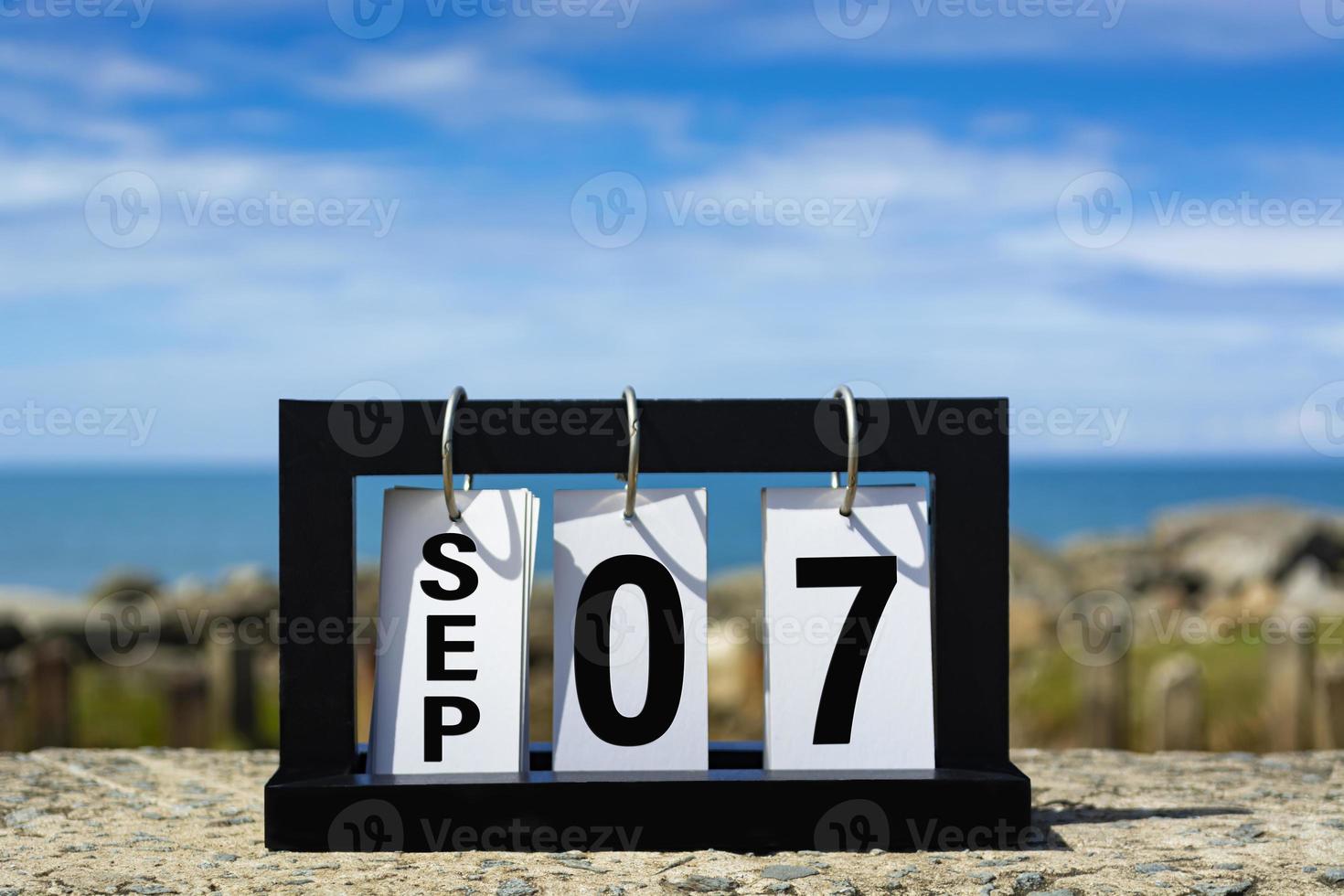 September 07 Kalenderdatumstext auf Holzrahmen mit verschwommenem Hintergrund des Ozeans. foto