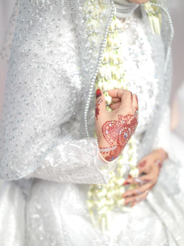 nahaufnahmehand mit henna, indonesischem traditionellem hochzeitskleid und henna. foto