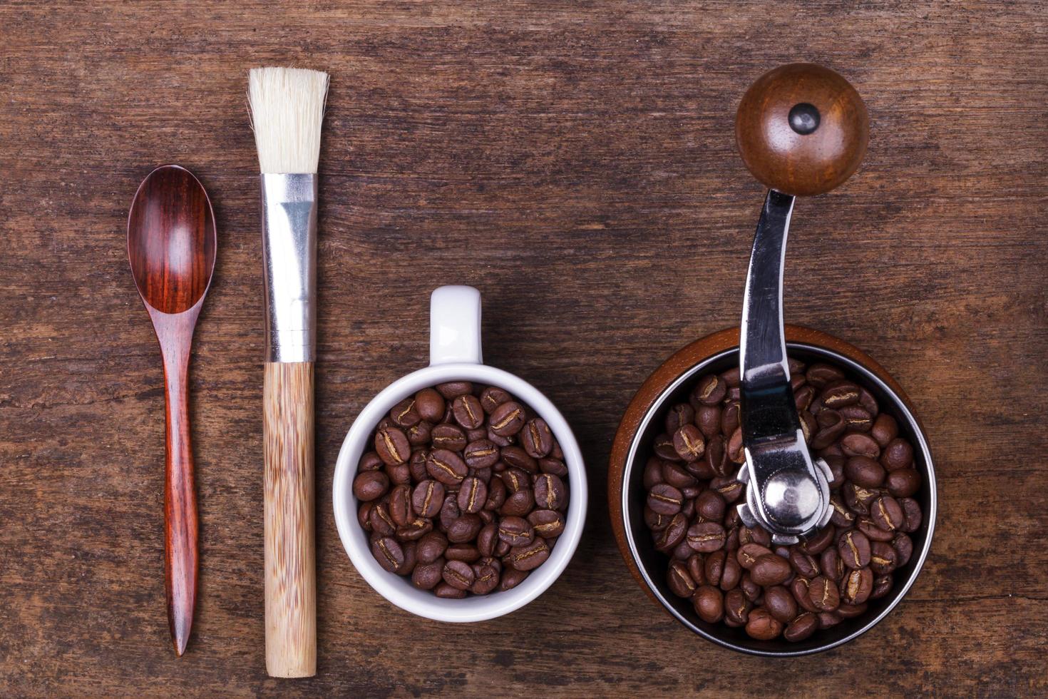 Tasse Kaffeebohnen und Löffel auf dem braunen Holzhintergrund foto