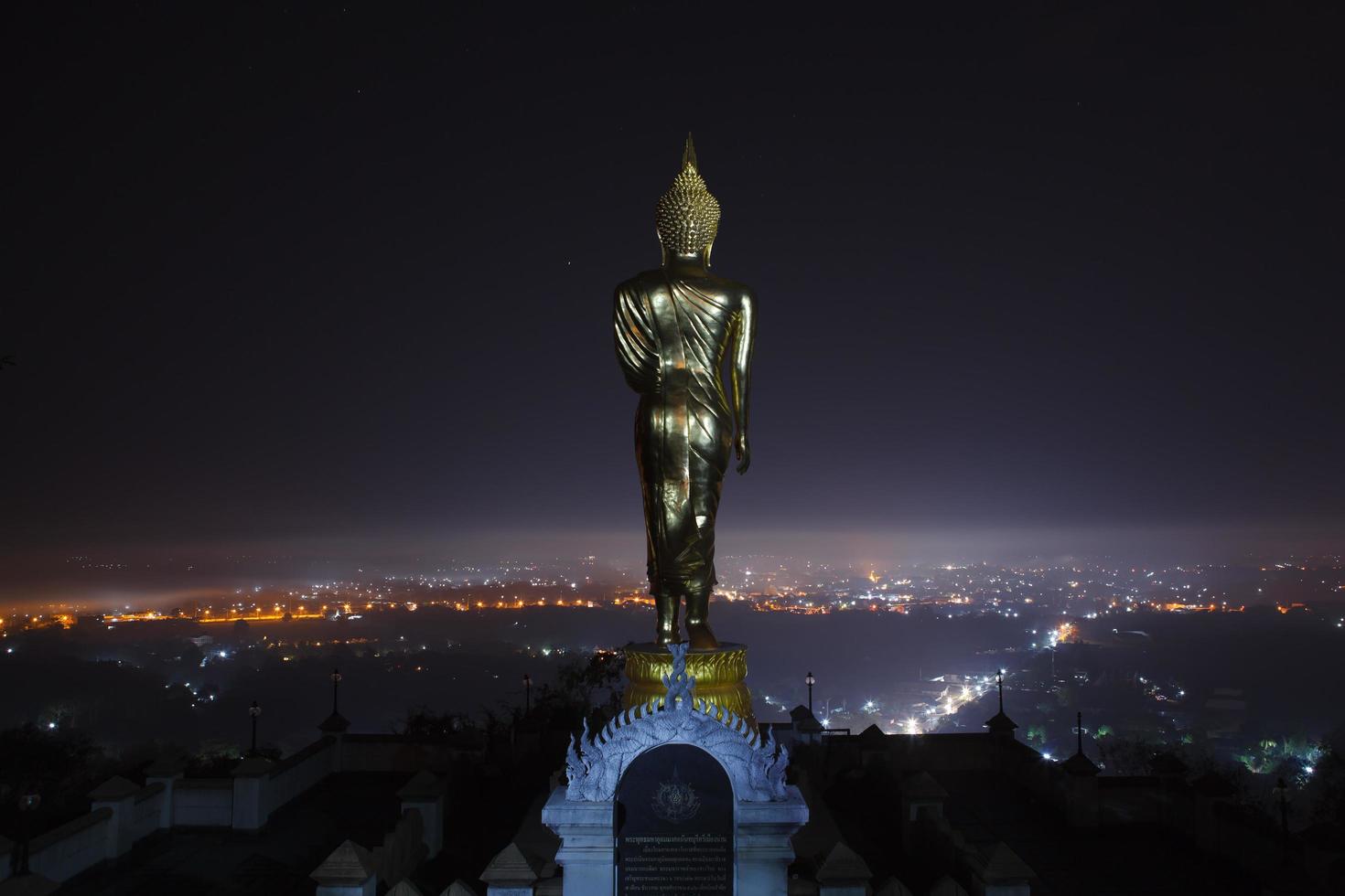Buddha-Statue, die nachts im Wat Phra That Khao Noi in Nan, Thailand steht foto