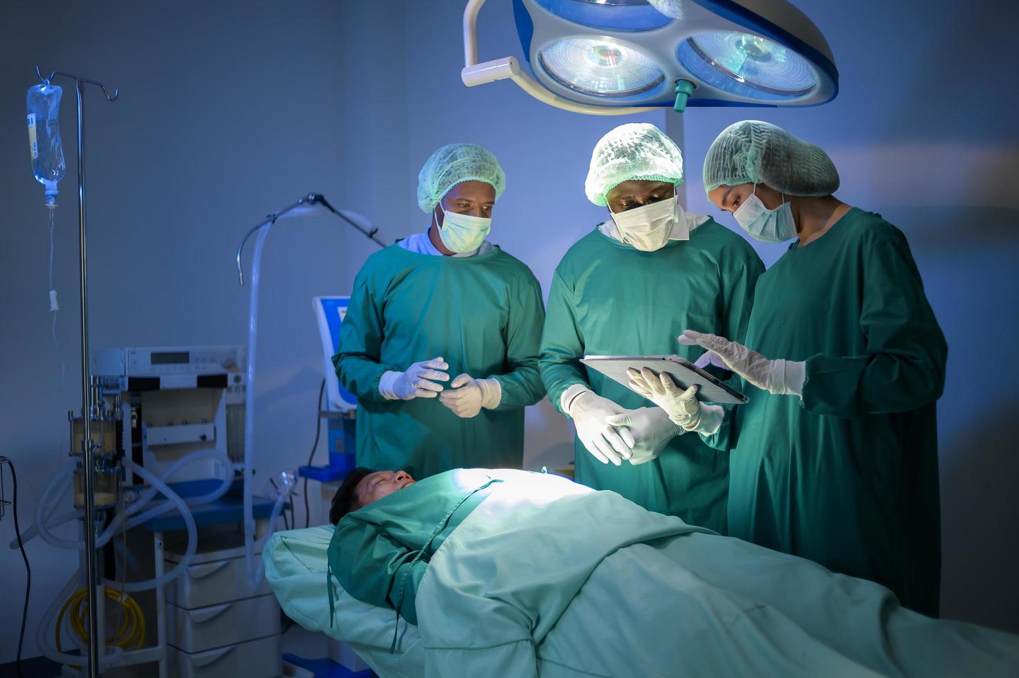 gruppe von professionellen chirurgen gemischter rassen, die im krankenhaus-operationssaal operieren, gesundheitskonzept. foto