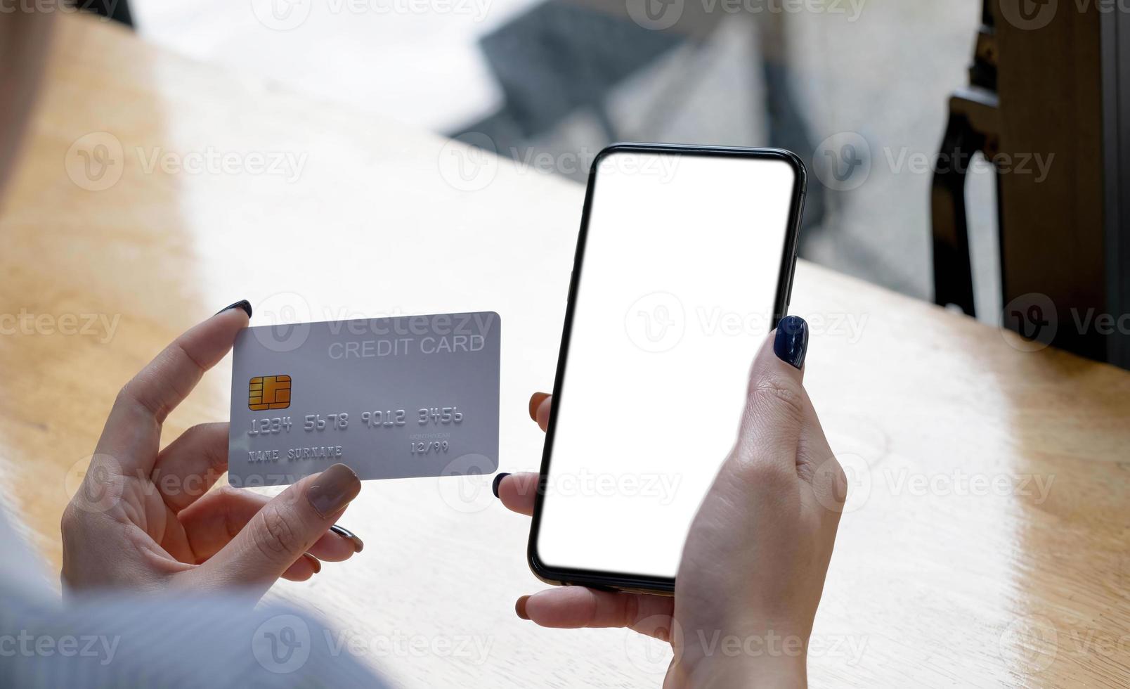 Onlinebezahlung. frau, die smartphone mit leerem bildschirm und kreditkarte hält und finanztransaktionen durchführt foto