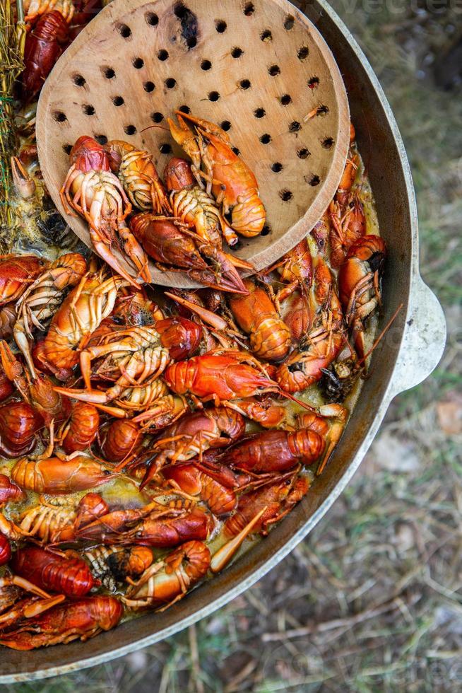 gekochte rote Krebse oder Langusten mit Kräutern. Krebse, die im Topf auf dem Feuer kochen foto