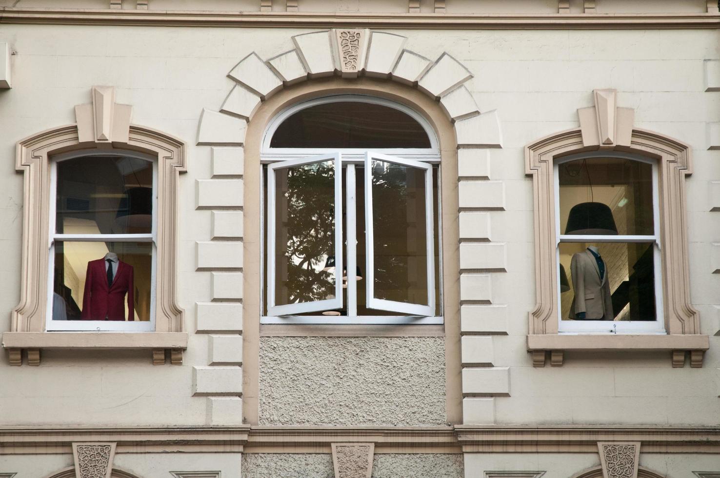 Fenster des Bekleidungsgeschäfts mit roten und weißen Anzügen in Italien foto