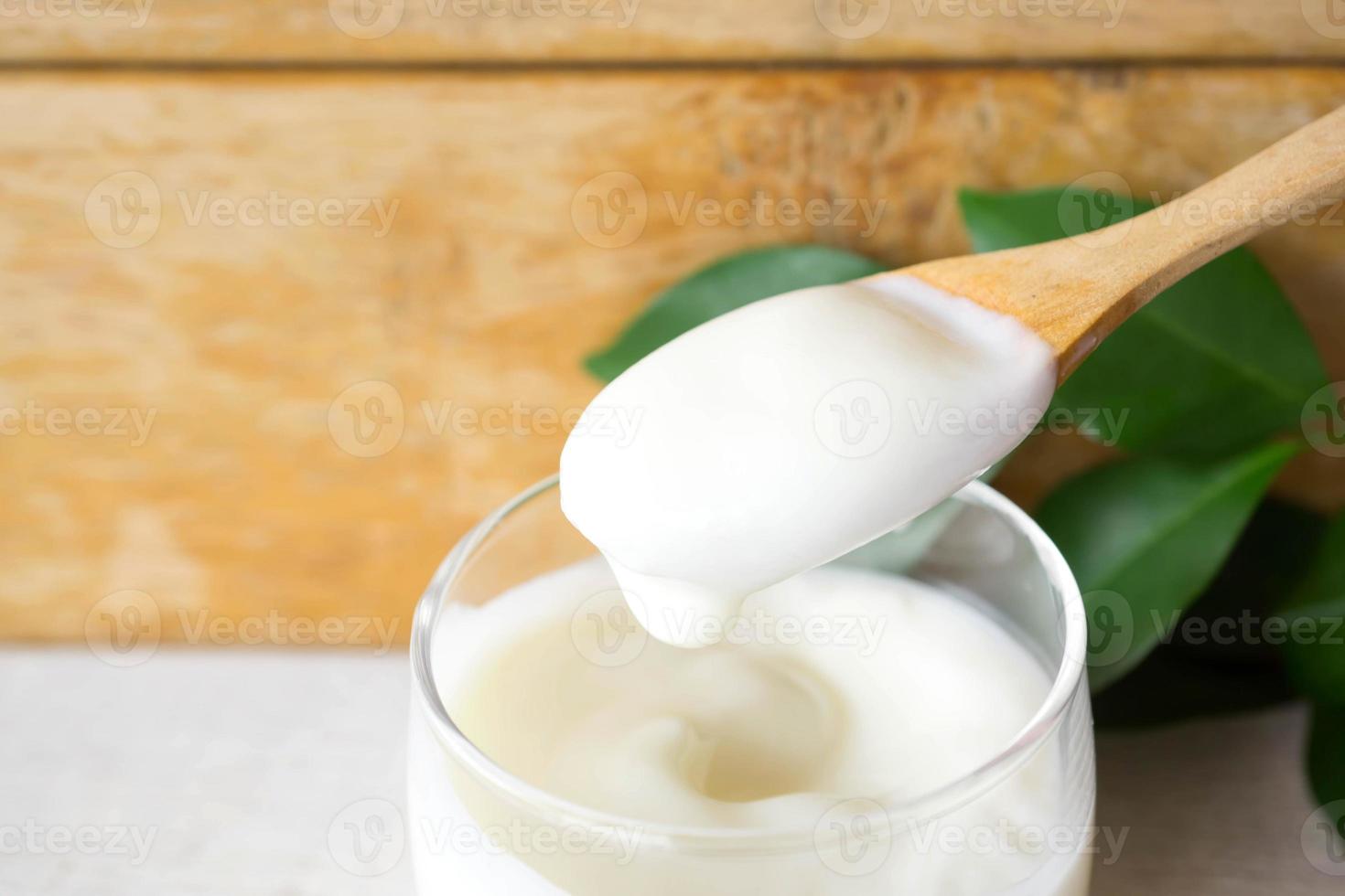 Löffel weißer hausgemachter Joghurt mit grünen Blättern. foto