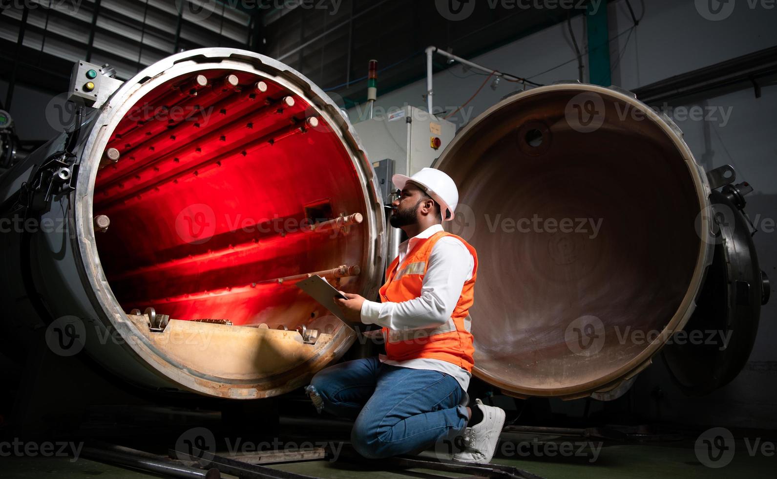 Der Chefingenieur der mechanischen Anlage führt eine Inspektion des Tunnels der Sterilisationsmaschine durch. um den Betriebszustand der Maschine zu überprüfen, um bereit zu sein foto