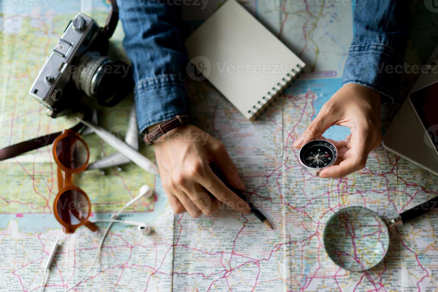hand haltender kompass für die planung von urlaubsreisen und zubehör für reisen foto