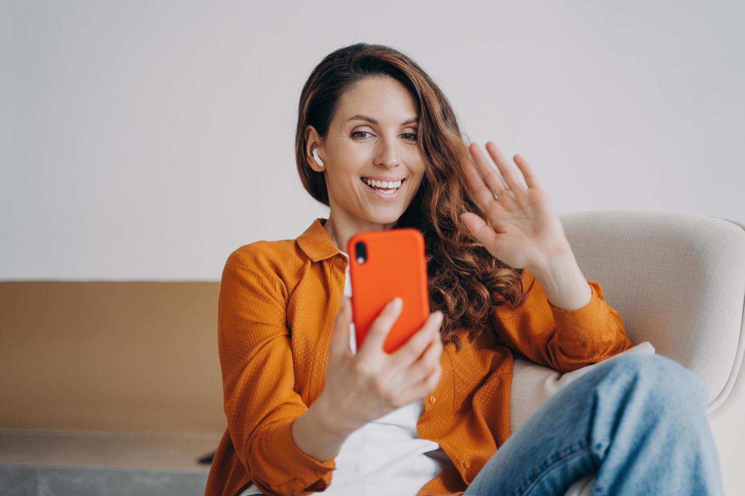 Glückliches europäisches Mädchen hat Videoanruf zu Hause. drahtlose kopfhörer, die bei online-konferenzen verwendet werden. foto