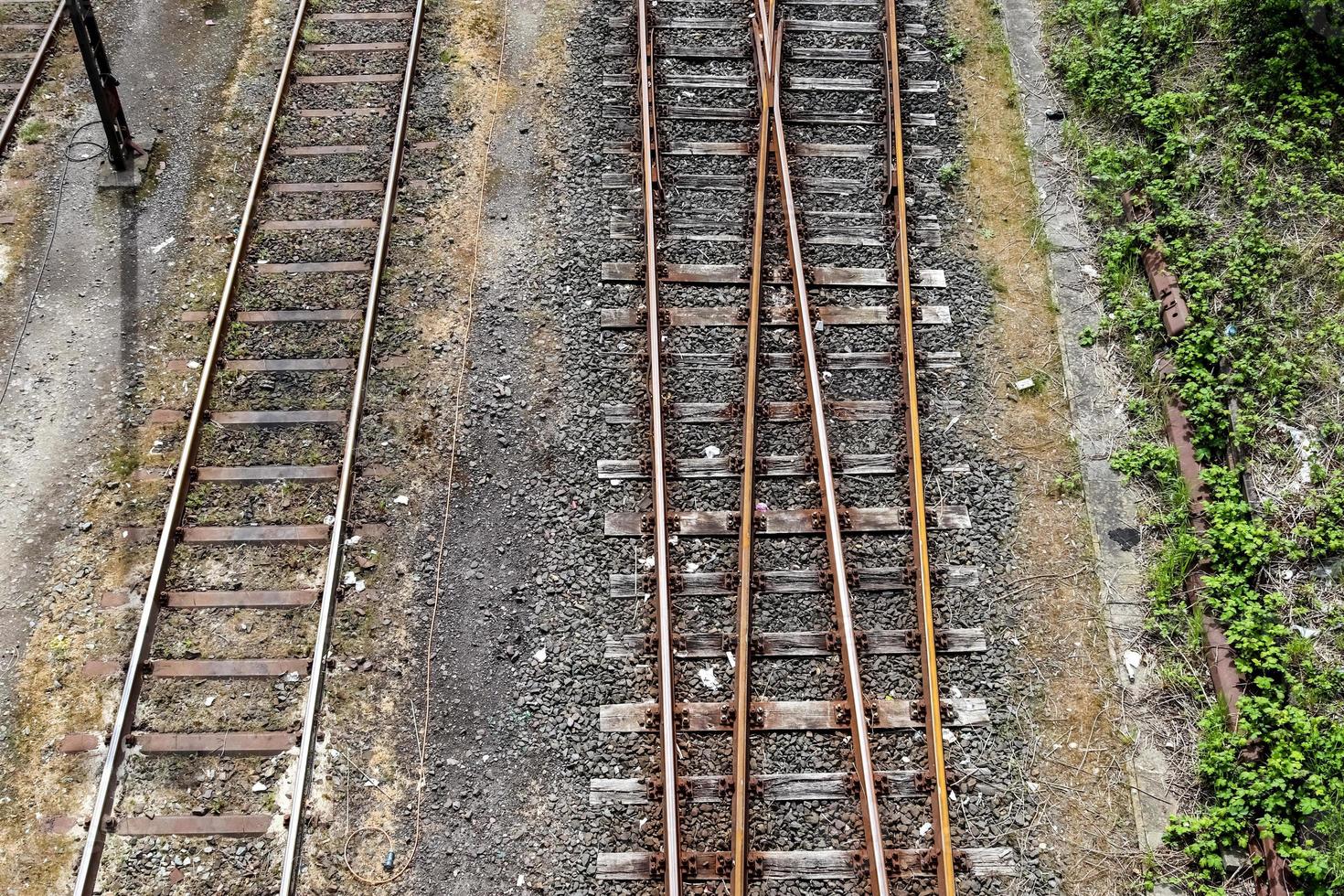 Mehrere Bahngleise mit Abzweigungen an einem Bahnhof perspektivisch und aus der Vogelperspektive foto