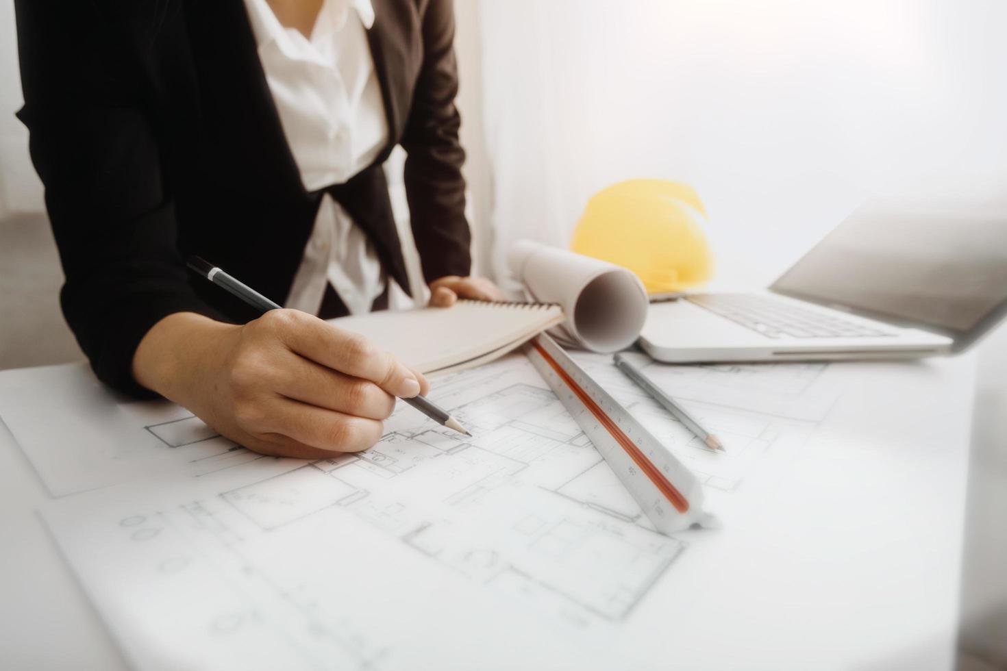 Business-Handarbeit und Laptop mit einem Architekturprojekt auf der Baustelle am Schreibtisch im Büro foto